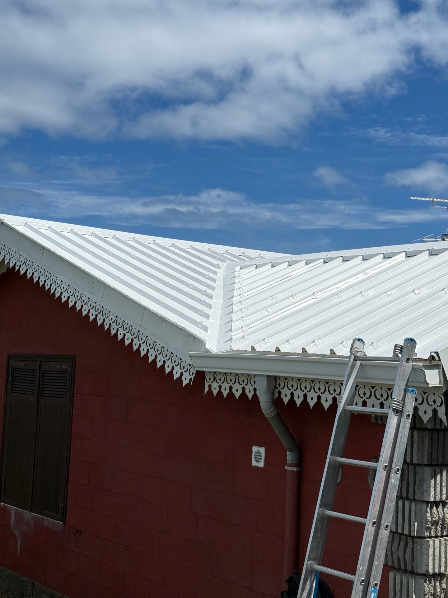 Toiture tôle blanche neuve · finition lambrequin créole à Réunion